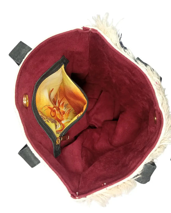 Red bag with a yellow interior and decorative flap featuring a cat design.