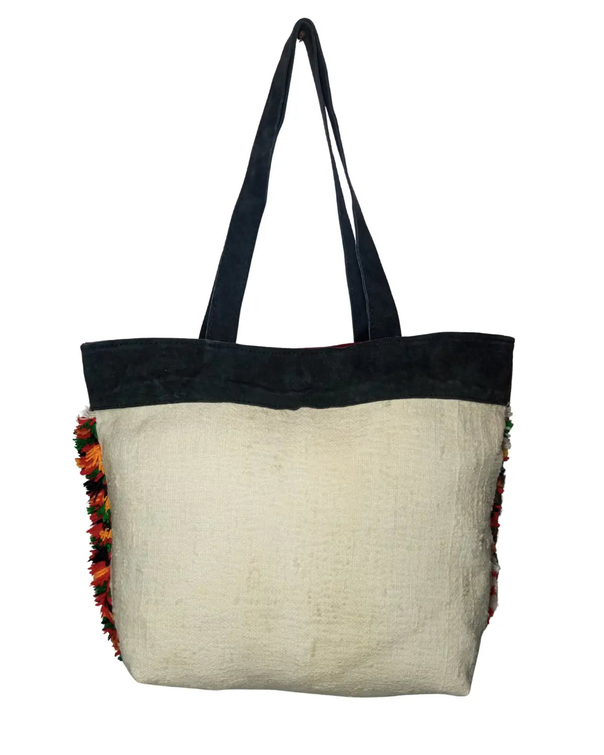 Tote bag with black top section and colorful fringe on a white background