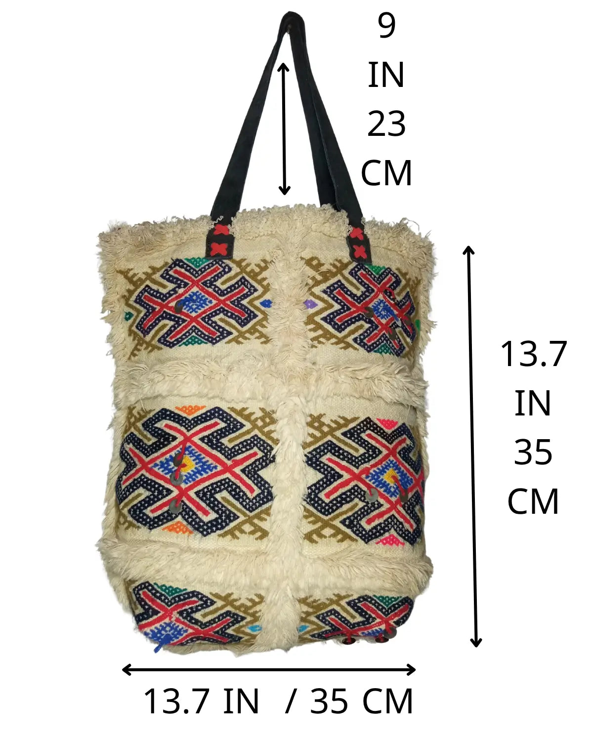 A detailed close-up shot of a colorful geometric pattern on a wool kilim bag. The embroidery features intricate cross-stitching in red, blue, yellow, and green, forming a traditional tribal design