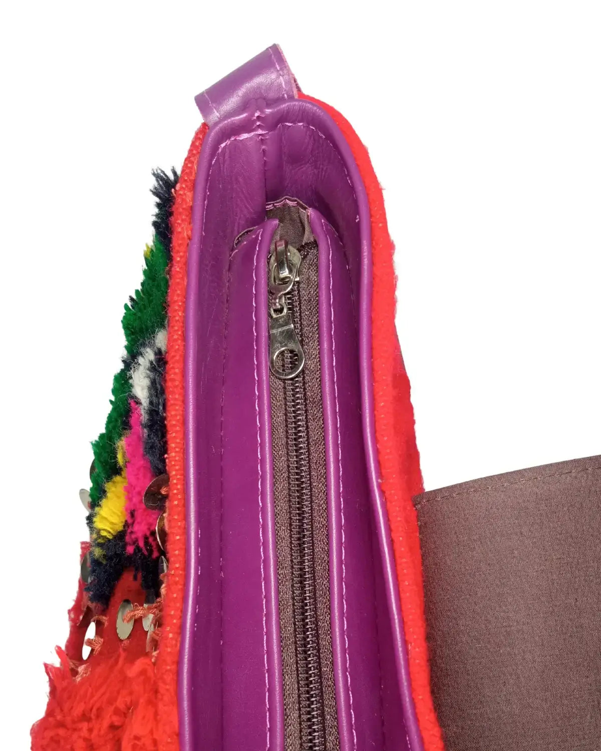 Close-up of a colorful zippered pouch with fringe details on a white background