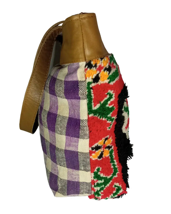 Colorful patchwork bag with a brown leather strap on a white background