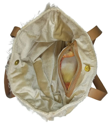 Beige textured bag with brown leather straps on a white background