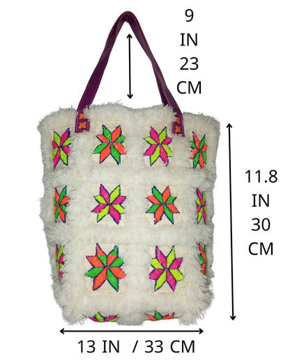 Detailed view of the vibrant neon embroidery on the white faux fur material of a retro tote bag, showing the star-shaped patterns in fuchsia, lime green, and orange
