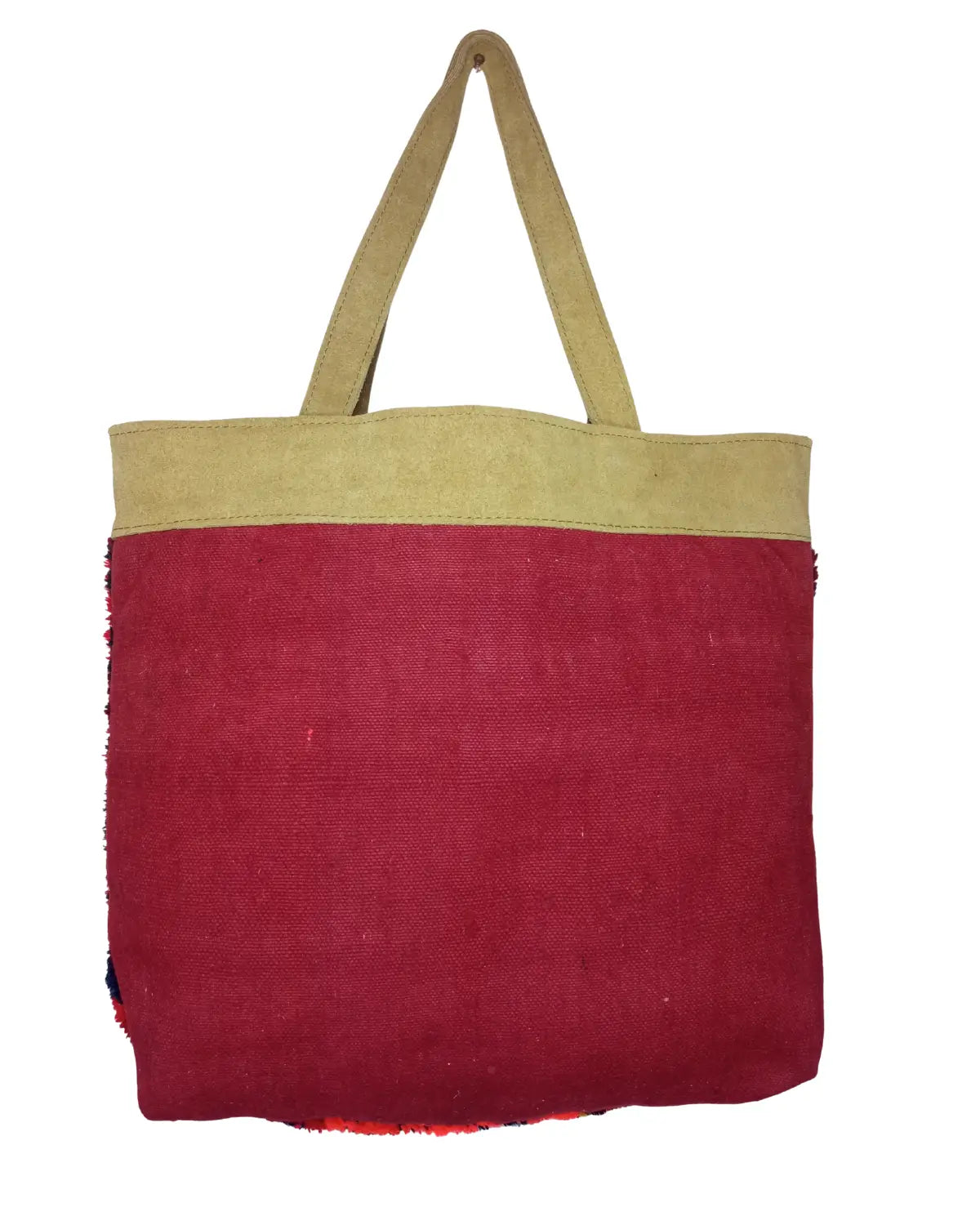A front-view of a one-of-a-kind handmade Moroccan carpet bag. The body is made from off-white, high-pile shag wool with a large, colorful geometric medallion in pink and green. The top band and handles are made of tan suede, and its dimensions are displayed.