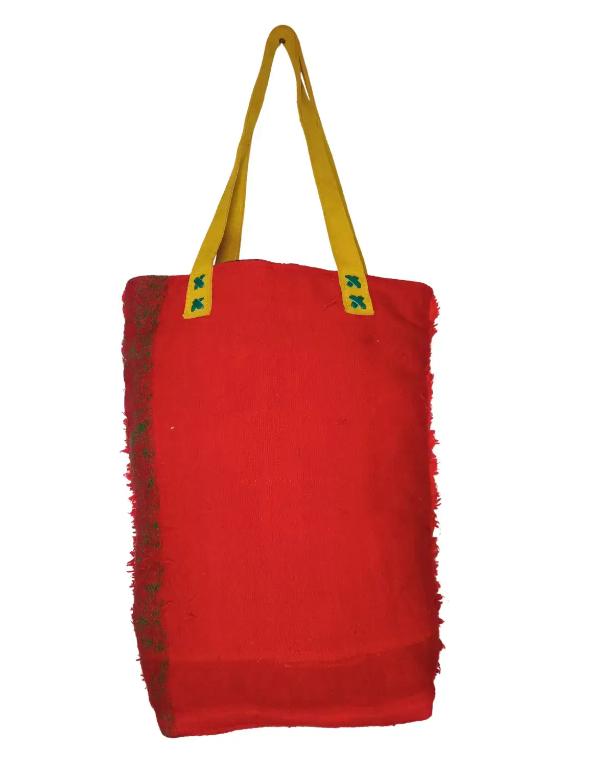 Front view of a handmade red Moroccan carpet bag on a white background. The bag has a fuzzy shag texture with four panels of tribal embroidery in yellow, black, pink, and green. It features mustard-yellow suede handles, and its dimensions are annotated.
